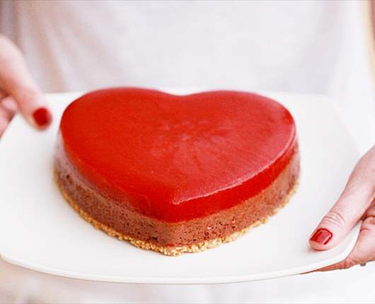 Pastel corazón de mousse de chocolate y coulis de fresas