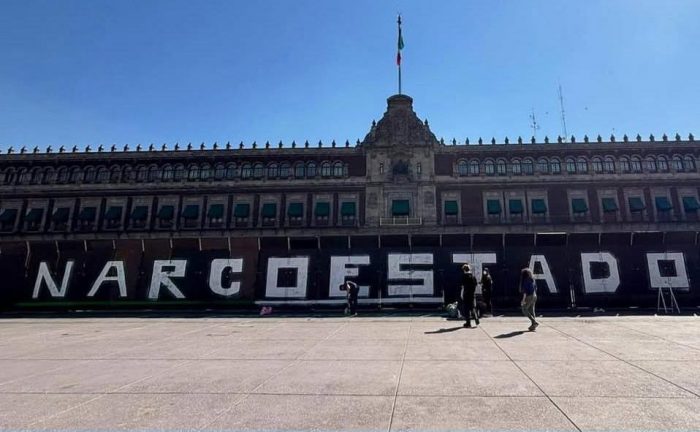 JÓVENES  COLOCAN LETRAS GIGANTES CON LA LEYENDA "NARCOESTADO" EN VALLAS DE PALACIO NACIONAL