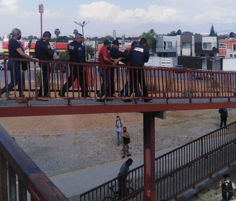 Policía y bombero rescatan a persona que intentó lanzarse de puente peatonal